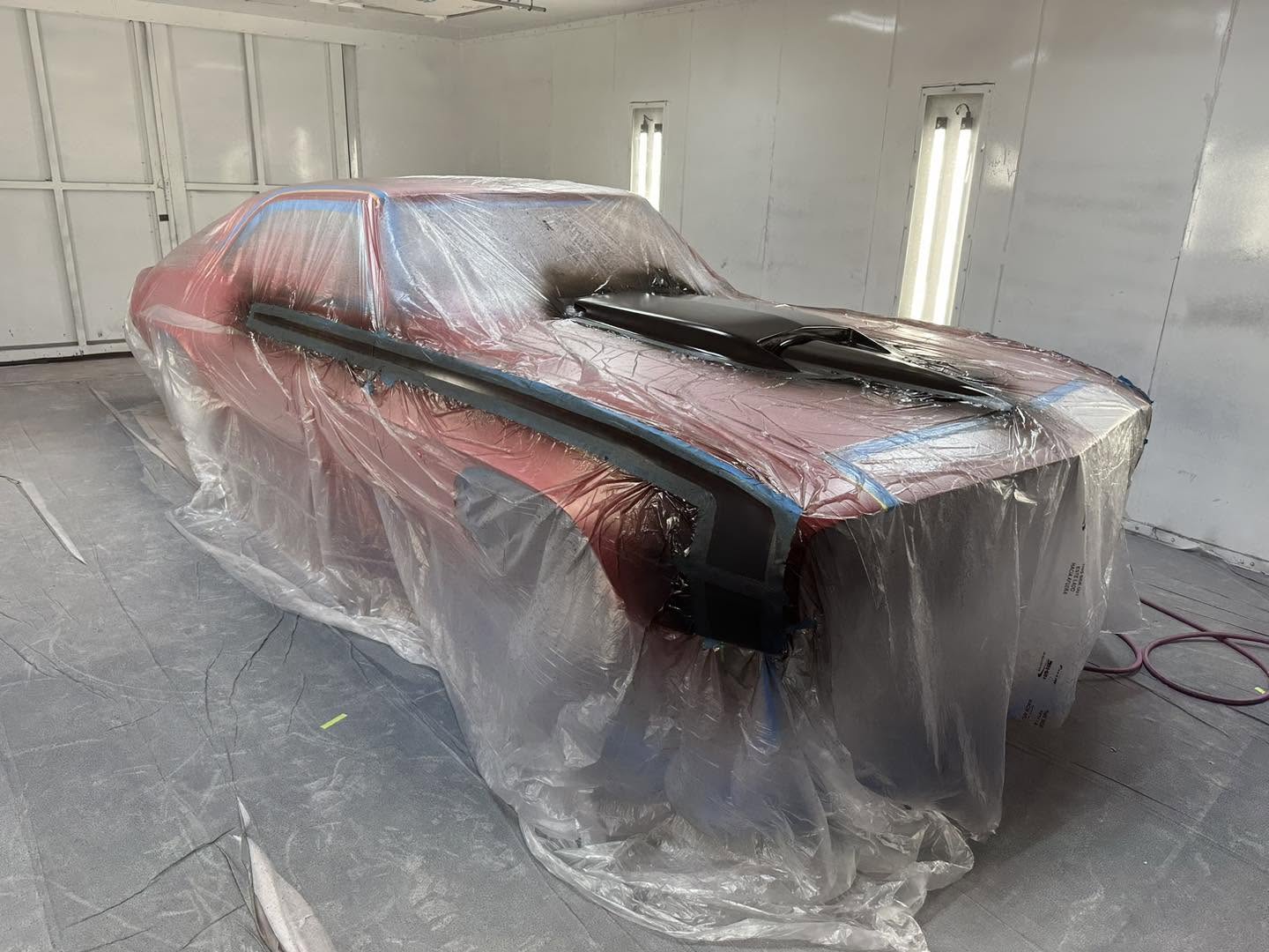 Solar Red Camaro masked in the paint booth before the black hood is sprayed