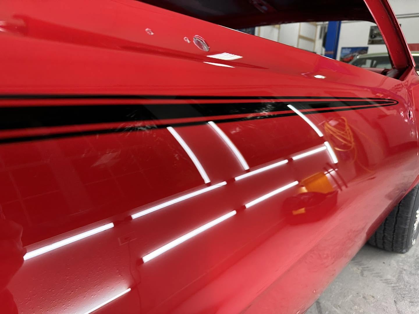 Close view of the black stripe and red pinline over Solar Red bodywork
